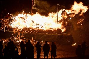 LERWICK, SCOTLAND - JANUARY 31: Guzier Jarl Lyall Gair and his Jarl throw their torches onto the galley on January 31, 2017 in Lerwick, Shetland. The traditional festival of fire, known as Up Helly Aa, takes place annually on the last Tuesday of January. The climax of the day came with participants wearing costumes as they hauled a Viking long boat through the streets of Lerwick to the edge of town where up to 1000 paraders set the vessel ablaze by throwing torches into the galley. (Photo by Jeff J Mitchell/Getty Images)