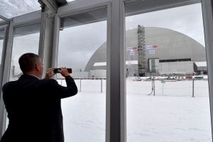 A man takes a picture of the Chernobyl's New Safe Confinement covering the 4th block of Chernobyl Nuclear power plant during the inauguration ceremony on on November 29, 2016. Ukraine unveiled the world's largest moveable metal structure over the Chernobyl nuclear power plant's doomed fourth reactor to ensure the safety of Europeans for future generations. The gigantic arch soars 108 metres (355 feet) into the sky -- making it taller than New York's Statue of Liberty -- while its weight of 36,000 tons is three times heavier than the Eiffel Tower in Paris. / AFP PHOTO / SERGEI SUPINSKY