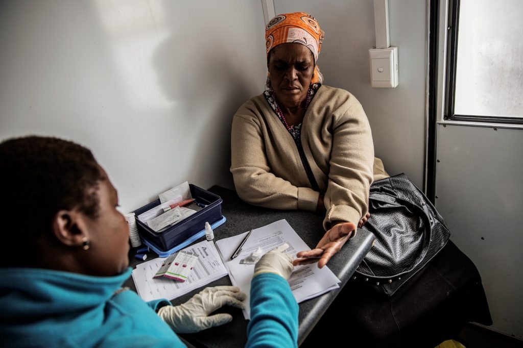 (FILES) This file photo taken on November 6, 2014 shows a South African woman getting tested for HIV by an health worker working with Doctors withouy borders (MSF) at a mobile clinic in Eshowe. South Africa on November 30, 2016 begins a major clinical trial of an experimental vaccine against AIDS, which scientists hope could be the "final nail in the coffin" for the disease. More than 30 years of efforts to develop an effective vaccine for HIV have not borne fruit, but for the first time since the virus was identified in 1983, scientists think they have found a promising candidate. / AFP PHOTO / GIANLUIGI GUERCIA