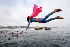 A swimmer disguised as Superman dives into the lake during the 78th "Coupe de Noel" (Christmas cup) swimming race in the Lake Geneva, on December 18, 2016 in Geneva. More than 1800 participants took part in the event, a 12-meter-long swimming off the Geneva's bank in the 7 degrees Celsius cold water. / AFP PHOTO / Fabrice COFFRINI