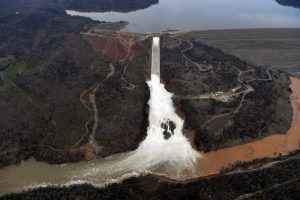 The Oroville Dam spillway releases 100,000 cubic feet of water per second down the main spillway in Oroville, California on February 13, 2017. Almost 200,000 people were under evacuation orders in northern California Monday after a threat of catastrophic failure at the United States' tallest dam. Officials said the threat had subsided for the moment as water levels at the Oroville Dam, 75 miles (120 kilometers) north of Sacramento, have eased. But people were still being told to stay out of the area. / AFP PHOTO / Josh Edelson