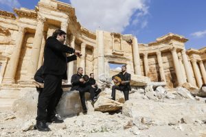 Syrian musicians play at the site of the damaged Roman amphitheatre in the ancient city of Palmyra in central Syria, during a tour organised by the Syrian army for journalists, on March 4, 2017. Syrian troops backed by Russian jets completed the recapture of the historic city of Palmyra from Islamic State (IS) group fighters on March 2, 2017, the Kremlin and the army said. / AFP PHOTO / Louai Beshara
