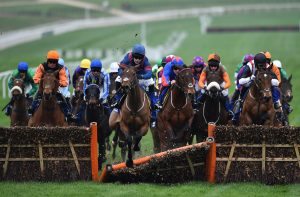'Arctic Gold' ridden by jockey Tom Humphries crashes through a hurdle in The Pertemps Network Final Handicap Hurdle Race on the third day of the Cheltenham Festival horse racing meeting at Cheltenham Racecourse in Gloucestershire, south-west England, on March 16, 2017. / AFP PHOTO / GLYN KIRK