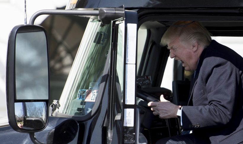 US President Donald Trump sits in the drivers seat of a semi-truck as he welcomes truckers and CEOs to the White House in Washington, DC, March 23, 2017, to discuss healthcare. / AFP PHOTO / JIM WATSON / ALTERNATIVE CROP