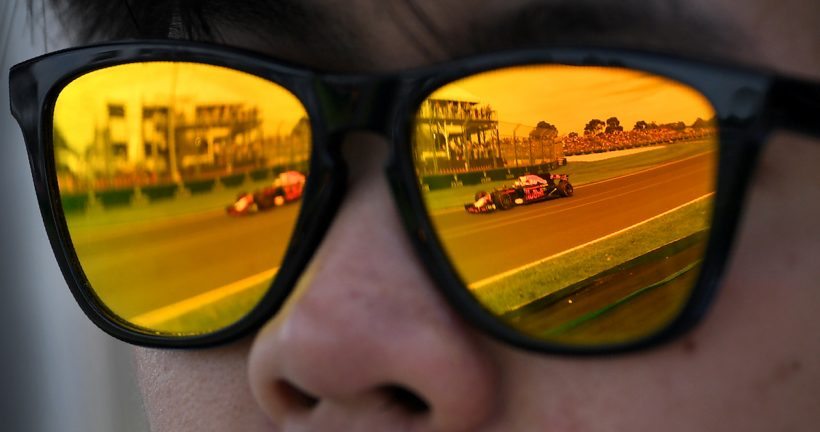 A Red Bull Racing car is reflected in a man's sunglasses during the first practice session at the Formula One Australian Grand Prix in Melbourne on March 24, 2017. / AFP PHOTO / WILLIAM WEST / -- IMAGE RESTRICTED TO EDITORIAL USE - STRICTLY NO COMMERCIAL USE --