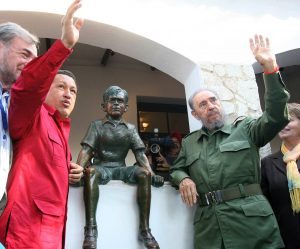 Presidents Hugo Chavez of Venezuela (L) and Fidel Castro of Cuba, wave at supporters as they stand next to a statue of a young Ernesto "Che" Guevara, the legendary Argentine-born revolutionary leader, in front of the house where he once lived and that has been now turned into a museum, in Alta Gracia, 40 km from the Argentine city of Cordoba, 22 July 2006. Castro and Chavez arrived in Argentina to attend at the Mercosur trade summit that took place Thursday and Friday in Cordoba. AFP PHOTO/PRESIDENCIA / AFP PHOTO / PRESIDENCIA / HO
