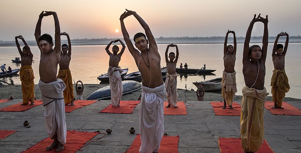 VARANASI, INDIA - APRIL 23: Young Indian Hindu Brahmins training to be priests perform yoga on a ghat on the Ganges River, holy to Hindus, at sunrise on April 23, 2014 in Varanasi, India. (Photo by Kevin Frayer/Getty Images)