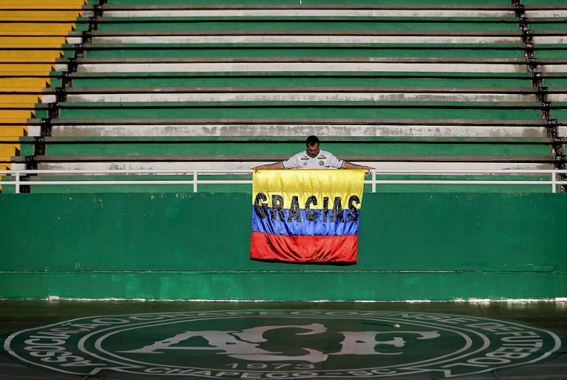 CHAPECO, BRAZIL - DECEMBER 01: A fan with the symbolic flag of Colombia paying tribute to the players of Brazilian team Chapecoense Real at the club's Arena Conda stadium in Chapeco, in the southern Brazilian state of Santa Catarina, on December 01, 2016. The players were killed in a plane accident in the Colombian mountains. Players of the Chapecoense team were among the 77 people on board the doomed flight that crashed into mountains in northwestern Colombia. Officials said just six people were thought to have survived, including three of the players. Chapecoense had risen from obscurity to make it to the Copa Sudamericana finals scheduled for Wednesday against Atletico Nacional of Colombia. (Photo by Buda Mendes/Getty Images)