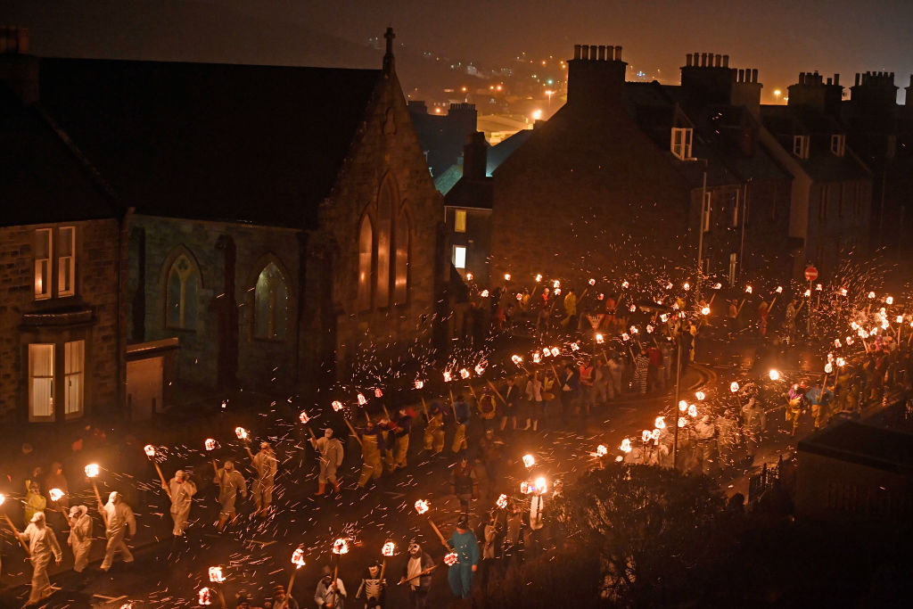 LERWICK, SCOTLAND - JANUARY 31: The Jarl squad begin to light torches at the culmination of Up Hell Aa on January 31, 2017 in Lerwick, Shetland. The traditional festival of fire, known as Up Helly Aa, takes place annually on the last Tuesday of January. The climax of the day came with participants wearing costumes as they hauled a Viking long boat through the streets of Lerwick to the edge of town where up to 1000 paraders set the vessel ablaze by throwing torches into the galley. (Photo by Jeff J Mitchell/Getty Images)