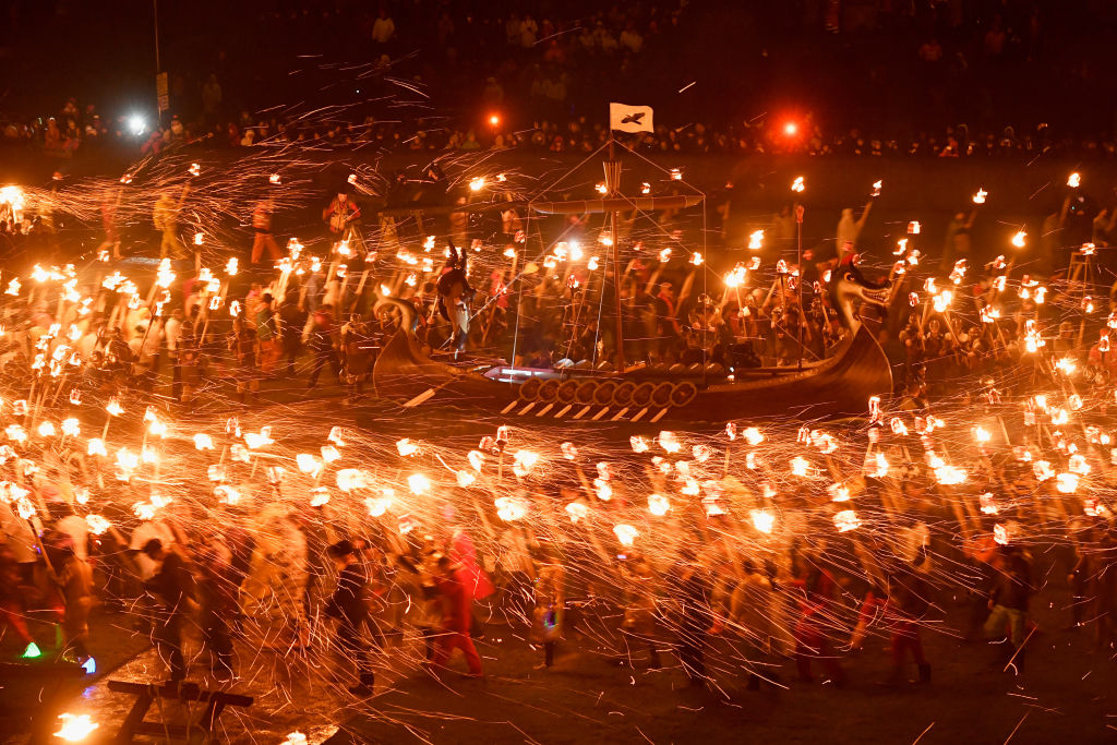 LERWICK, SCOTLAND - JANUARY 31: Guzier Jarl Lyall Gair and his Jarl throw their torches onto the galley on January 31, 2017 in Lerwick, Shetland. The traditional festival of fire, known as Up Helly Aa, takes place annually on the last Tuesday of January. The climax of the day came with participants wearing costumes as they hauled a Viking long boat through the streets of Lerwick to the edge of town where up to 1000 paraders set the vessel ablaze by throwing torches into the galley. (Photo by Jeff J Mitchell/Getty Images)