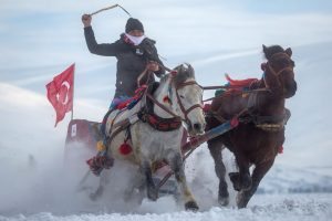 CILDIR, TURKEY - FEBRUARY 04: A man whips his horses as he takes part in the horse and sled racing across the frozen Cildir Lake during the Cildir Lake Golden Horse Festival on February 4, 2017 in Cildir, Turkey. The Cildir Golden horse festival is a traditional turkish festival started four years ago to bring together horsemen from around the region to compete in traditional horse based events. The festival takes place on the towns frozen lake amid temperatures of -5 to -15 degrees. Participants compete in several events including horse-drawn sled racing, horse racing, traditional horseback archery and the team event of Jereed (horseback javelin). (Photo by Chris McGrath/Getty Images)