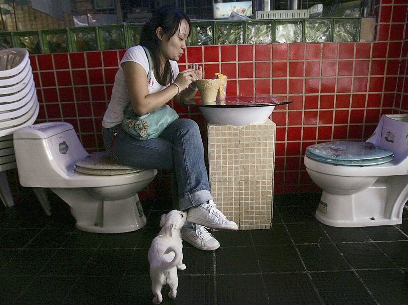 SHENZHEN, CHINA - OCTOBER 24: (CHINA OUT) A diner sits on a toilet style seat while having a drink at a toilet- themed restaurant on October 24, 2006 in Shenzhen of Guangdong Province, China. Food arrives in bowls shaped like Western-style toilets or Asian-style "squat pots". The theme has attracted droves of novelty-seeking young people who come to play with their food and gross out their friends. (Photo by China Photos/Getty Images)
